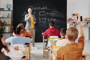 teacher teaching class at the chalkboard